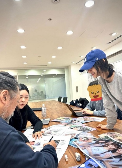 村上隆（左）の作業を見守るミン・ヒジン代表（右）